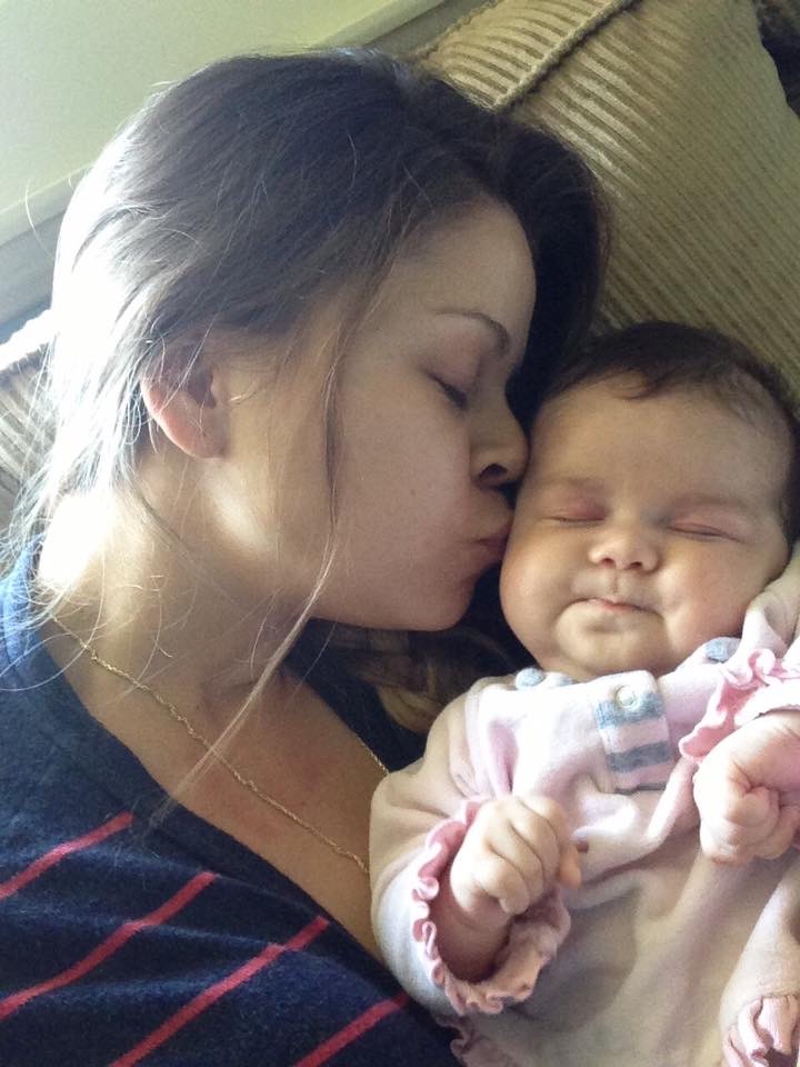 Tatiana holding and kissing her baby daughter Savannah